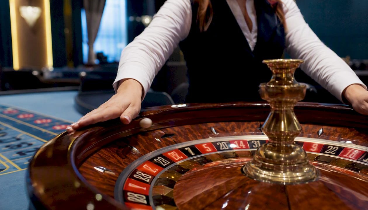 Hands spinning live roulette wheel