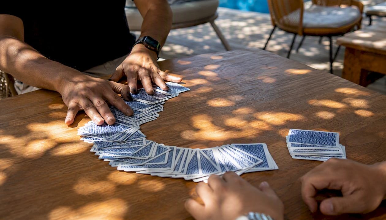 Hands dealing Andar Bahar cards on table