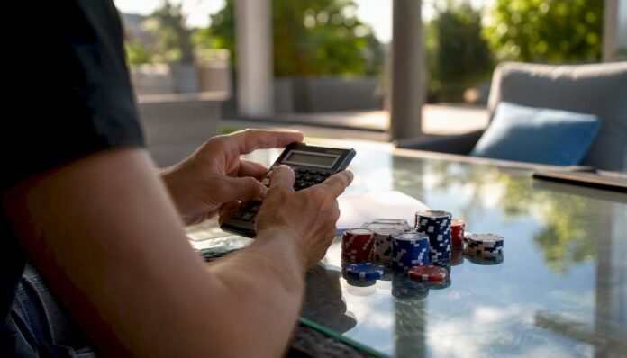 Hands calculating betting odds with chips and calculator