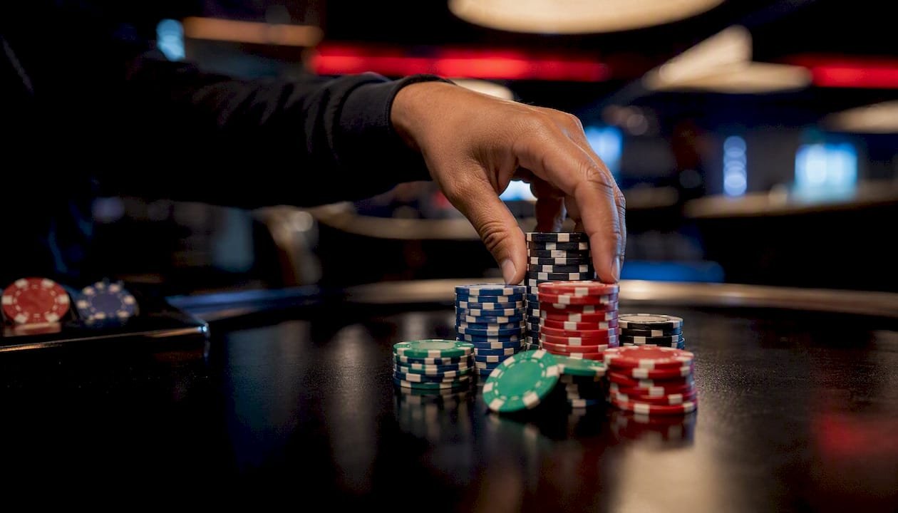 Hand placing casino chips on betting table