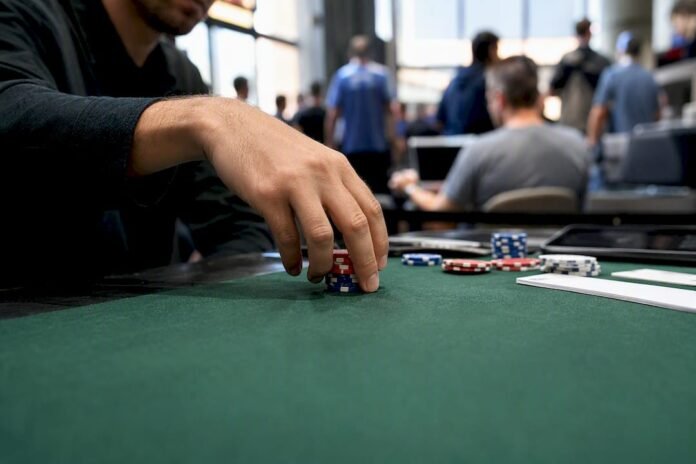 Hand placing chips on Indian sports betting counter